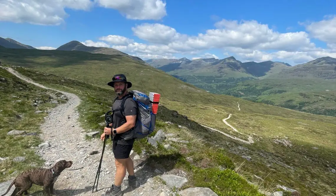 Stephen on the west highland way hike, sunny picture with hills in the background