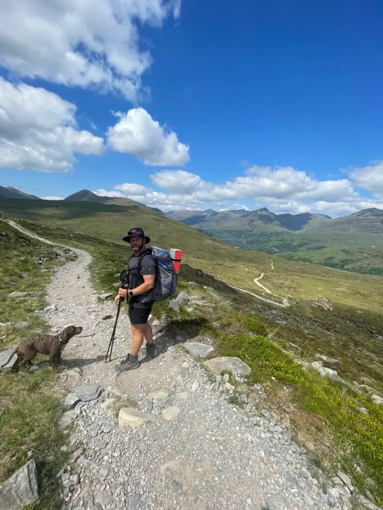 Stephen on the west highland way hike, sunny picture with hills in the background