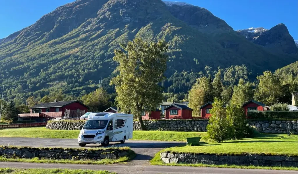 Peanut, Stephen and Terri’s motorhome, parked below a mountain beside red cabins