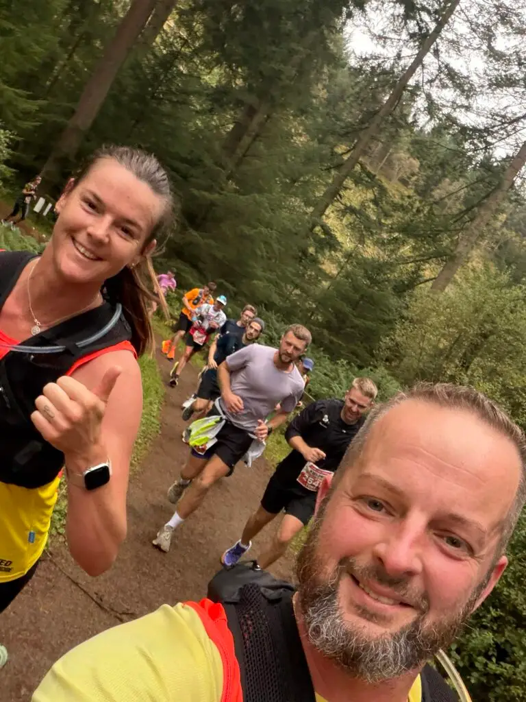 Stephen and Terri running together in a forest with others.